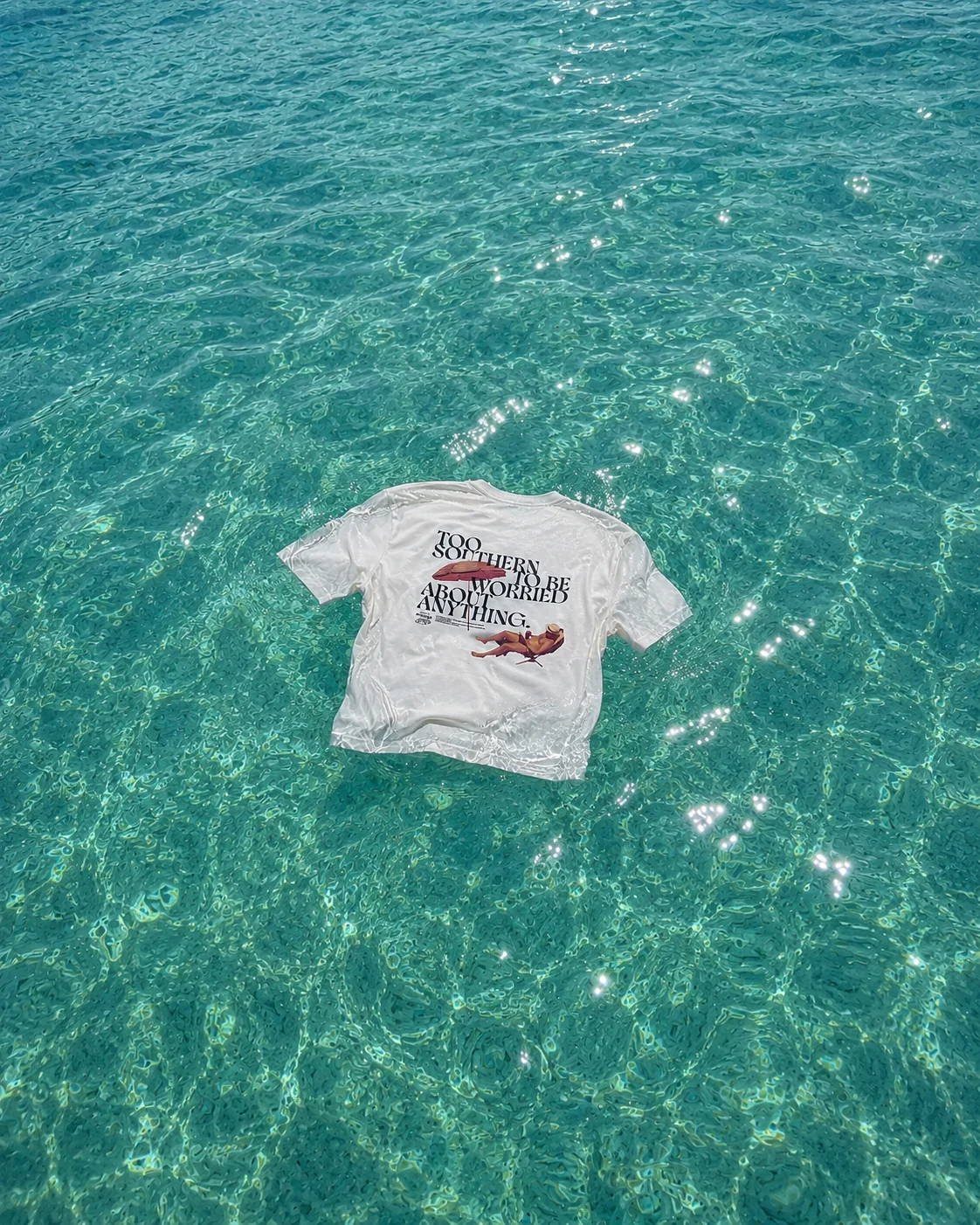 Born in Monge t-shirt floating in clear Mediterranean water